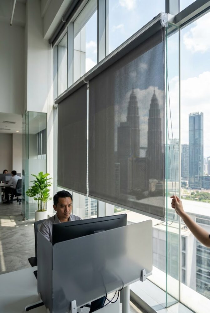 Sleek commercial roller blinds installed in a modern corporate office in Kuala Lumpur to reduce screen glare